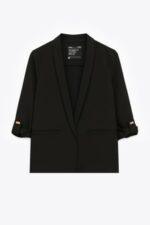 Veste noire femme chic sur fond neutre, basique élégant et polyvalent